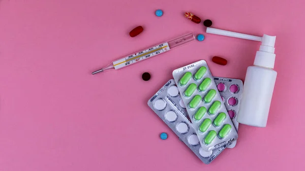 Instrumentos médicos y medicamentos sobre un fondo rosa, aísla — Foto de Stock