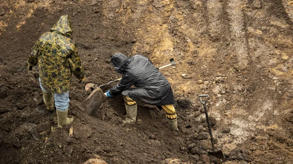Metal dedektörlü bir işçi arkeolojik alanda değerli eşyalar arıyor.