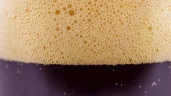 ガラスの中のダークビールの泡マクロ写真背景テクスチャ — ストック写真