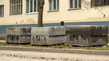 Çimenlerin üzerinde beton kaldırım blokları var.