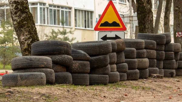 Zusammengefaltete alte Autoreifen liegen auf dem Boden neben der Straße, Hintergrund — Stockfoto