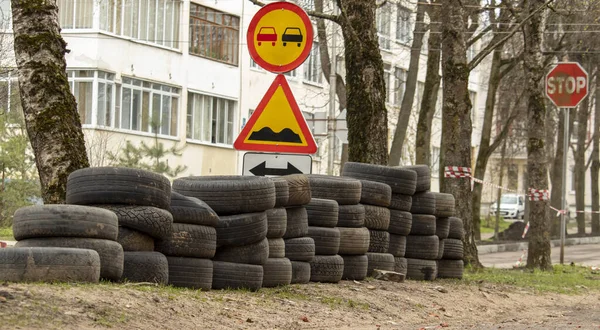 folded old car tires lie on the ground near the road, background