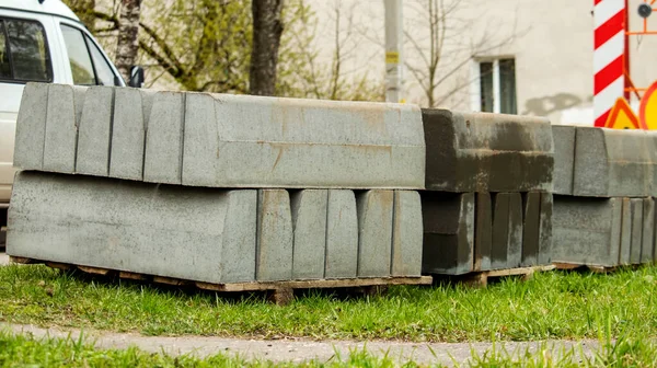Blocchi pavimentazione di cemento accatastati si trovano sull'erba, sfondo — Foto Stock