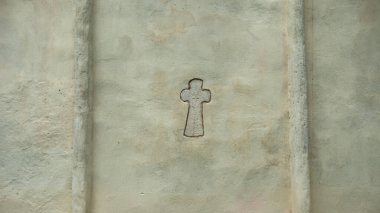 christian cross on white wall of stone church, backgrounds