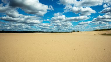 Arka planda mavi bulutlu gökyüzü, arka planda kumlu bir kumsal.,