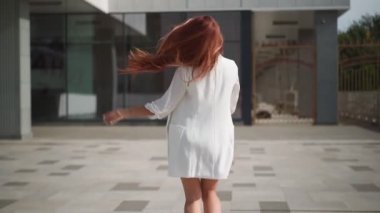 Elinde not defteri olan mutlu ve güzel bir kadın başarısı ve özgürlüğüyle mutlu bir şekilde yürüyor ve gülümsüyor. Üniversitede okuduktan sonra kitap okuyan oyuncu bir kadın öğrenci. Yavaş çekim. 