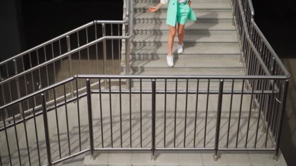 Красивая Стройная Женщина Очках Модный Бирюзовый Костюм Спускается Лестнице Рядом — стоковое видео