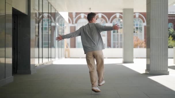 선글라스를 남자가 활발히 달리고 있습니다 도시의 거리를 기쁨과 행복으로 추면서 — 비디오