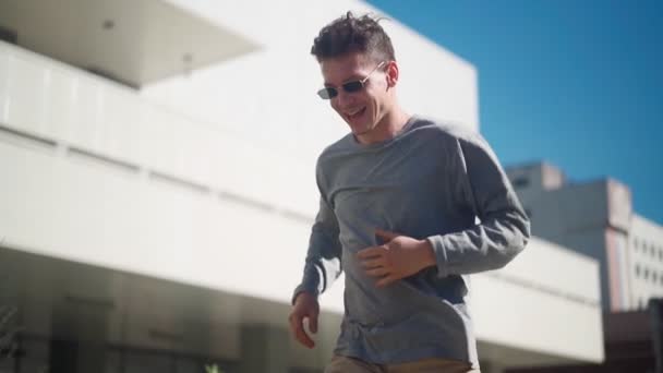 Przystojny Szczęśliwy Człowiek Okularach Przeciwsłonecznych Aktywnie Biega Uśmiecha Się Tańczy — Wideo stockowe