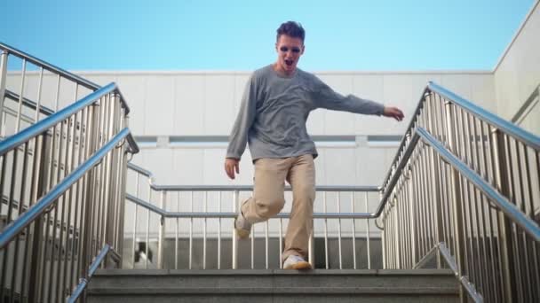 선글라스를 남자가 활발히 달리고 있습니다 계단을 내려가는 기쁨과 행복으로 추면서 — 비디오