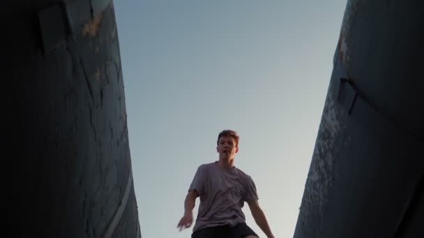 Homme heureux ludique court et saute dans la lumière du soleil. Liberté et bonheur. Vue du bas. Mouvement lent — Video