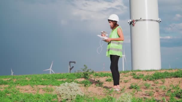 专业的生态工程师 身穿制服 头戴头盔 手持遥控装置 在美丽的天空彩虹背景下操作风力涡轮机的无人驾驶飞机 替代电能 慢动作 — 图库视频影像