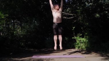 Uzun saçlı komik şişman adam şehir parkında kilo vermek için jimnastik yapıyor. Kilolu adam doğada fitness yapıyor. Yavaş çekim