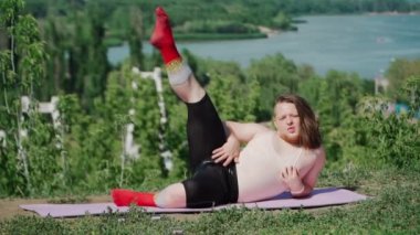 Dar tişörtlü, Uzun Saçlı Oyuncu Şişman Adam ve Açık havada Kilo Vermek İçin Spor Yapıyor. Kilolu bir adamın parkta spor yapan bir kızı betimlemesi. Yavaş çekim