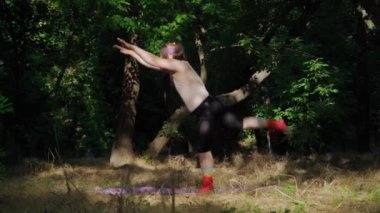 Uzun saçlı, komik kadın elbiseli, ormanda spor yapan, kilolu, etkileyici bir adam. Kilo Veren Şişko Kız, Kilo Vermek İçin Jimnastik Yapıyor.