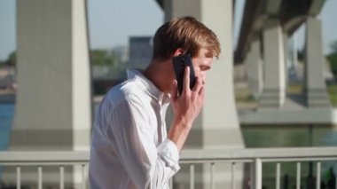 Şehir parkında, sokakta cep telefonuyla konuşan sinirli bir adam. Saldırgan adam cep telefonuna bağırıyor. Yavaş çekim