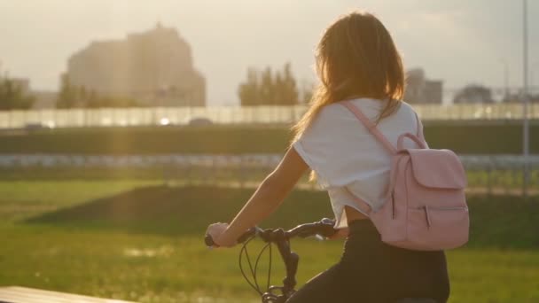 Красива Молода Жінка Їде Велосипеді Міському Парку Під Час Заходу — стокове відео