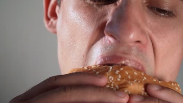 Der Mann Isst Einen Hamburger Junk Food Ungesunde Essgewohnheiten Nahaufnahme — Stockvideo