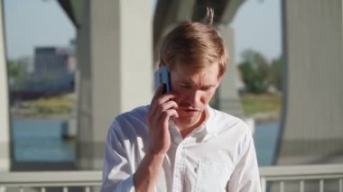 Şehir parkında, sokakta cep telefonuyla konuşan sinirli bir adam. Saldırgan adam cep telefonuna bağırıyor. Yavaş çekim