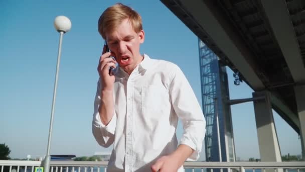 Злой Человек Эмоционально Разговаривает Мобильному Телефону Улице Городском Парке Агрессивный — стоковое видео