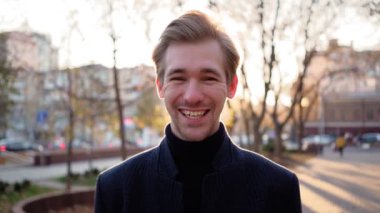 Portre. Mutlu Avrupalı adam, şehrin arka planında komik bir şekilde gülüyor. Duygusal.