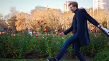 Belge klasörlü mutlu bir iş adamı şehir merkezinde yürür ve dans eder..