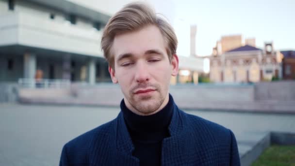 Portrait of handsome tired man looking at camera against an urban background — Stock Video