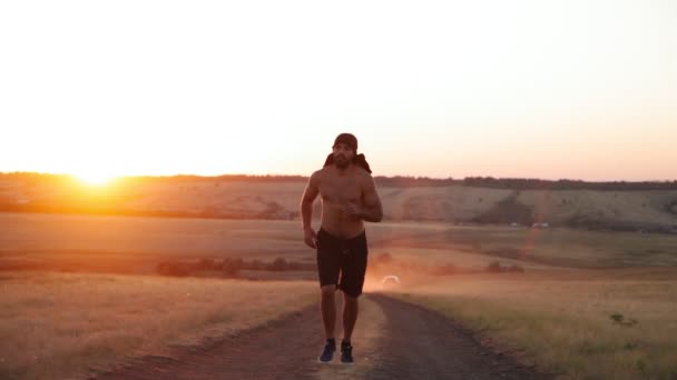 Muscoloso, atletico uomo arabo con la barba in esecuzione su un bellissimo sfondo tramonto. — Video Stock