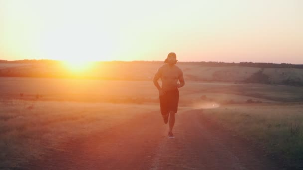 Gespierde, atletische Arabische man met baard draait op prachtige zonsondergang achtergrond. — Stockvideo