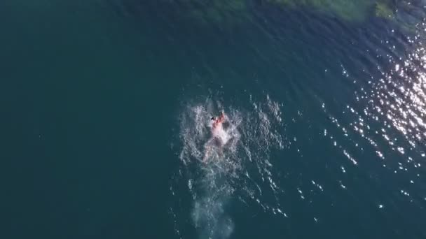 Αεροφωτογραφία. Ο μυώδης άντρας κολυμπάει σε κρυστάλλινα νερά. Καλοκαιρινές διακοπές — Αρχείο Βίντεο