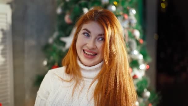 Retrato. Hermosa mujer de pelo rojo feliz fondo árbol de Navidad y sonriendo — Vídeos de Stock