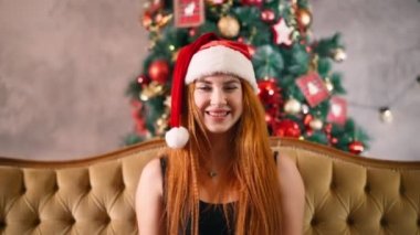 Noel Baba şapkalı bir kadın yatakta iki büklüm olur ve yılbaşı hediyesini uzatır..