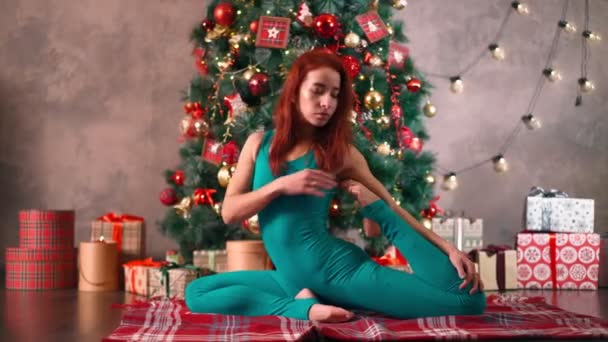 Slim woman practices yoga background Christmas tree. Weight loss after New Year — Stock Video