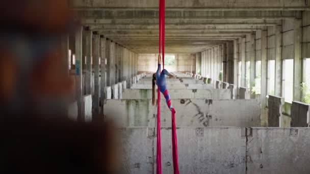 Femme athlétique aerialist fait acrobatique tour sur les toiles bâtiment abandonné — Video