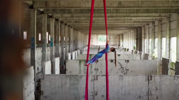 Mulher atlética aerialista faz truque acrobático em telas edifício abandonado — Vídeo de Stock