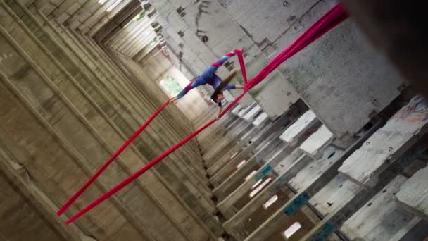 Женская воздушная гимнастка выполняет акробатический трюк с удивительным расколом заброшенных — стоковое видео