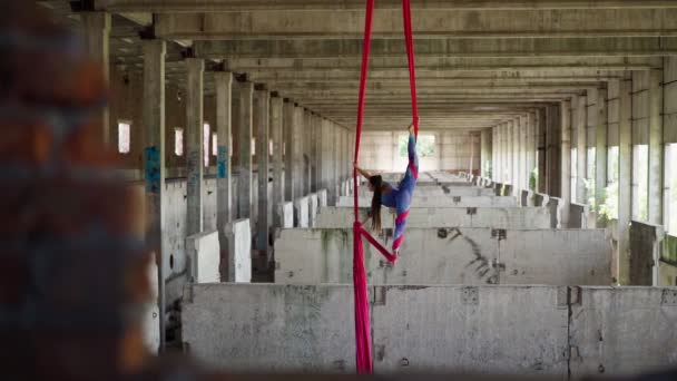 Mulher ginasta aérea executa truque acrobático com uma incrível divisão abandonada — Vídeo de Stock