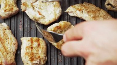 Ev yapımı ızgarada nefis kızarmış et pişirmek. Lezzetli domuz eti. Aşçı eti çatalla çevirir. Kapatın. Üst görünüm.