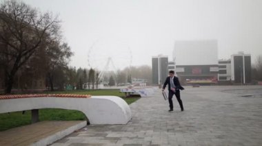 Takım elbiseli ve kravatlı başarılı bir işadamı zafere koşuyor ve zıplıyor.