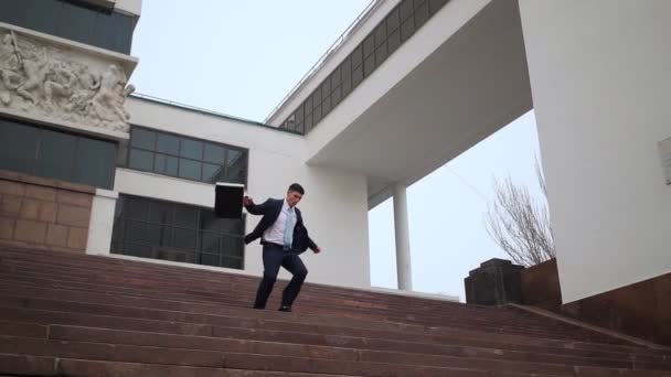 Heureux homme d'affaires réussi descend ludique escaliers près de l'immeuble de bureaux. — Video