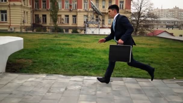 O empresário bem sucedido no terno apressa-se para trabalhar e salta sobre um obstáculo. Parkour. — Vídeo de Stock