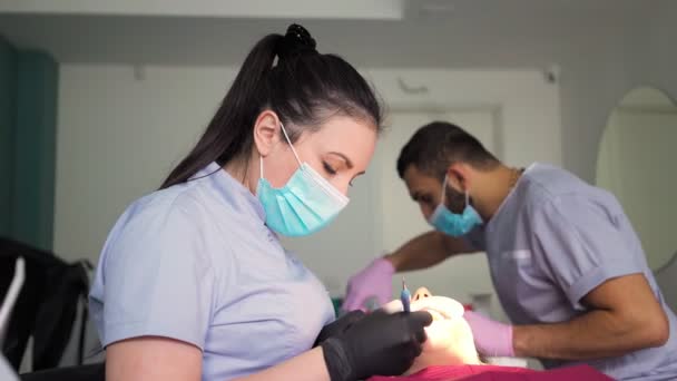 Dois Médicos Homem Mulher Máscaras Protetoras Uma Clínica Odontológica Servem — Vídeo de Stock
