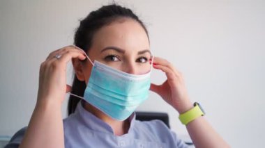 Hastane ofisinde tıbbi maske takan genç ve güzel bir kadın. Sağlık ve Tıp Konsepti 'nden. Yakın plan portre.