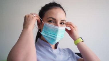 Hastane ofisinde tıbbi maske takan genç ve güzel bir kadın. Sağlık ve Tıp Konsepti 'nden. Yakın plan portre.