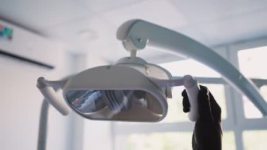 Dişçi kadın diş hekimliği kliniğine tıbbi lamba da dahil. Ameliyata hazırlanıyorum. Tıp ve sağlık hizmetleri kavramı. Kapat..