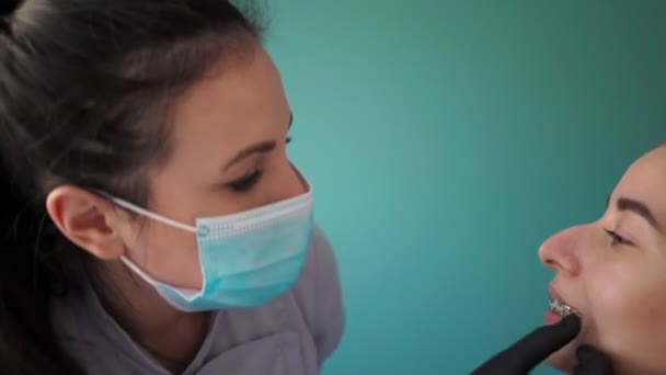 Nainen Lääkäri Hammaslääkäri Tutkii Nuori Tyttö Potilas Hammasraudat Hammaslääkärin Toimistossa — kuvapankkivideo