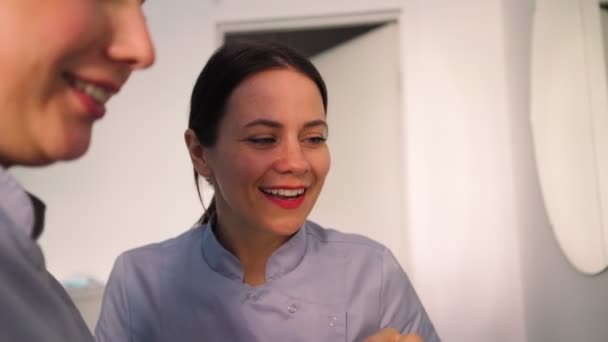 Duas Médicas Bonitas Jovens Sorriem Discutem Plano Tratamento Que Senta — Vídeo de Stock