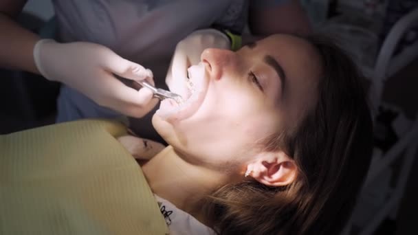 女性歯科医歯科室で患者の女の子と仕事をしています ブレースの設置と歯のアライメント ヘルスケアと医療の概念 — ストック動画