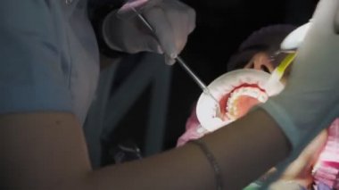 Koruyucu Kalkandaki Kadın Diş Hekimi ve Yüz Maskesi Diş Hekimliğinde Diş teli takan bir kadın hastayla Tıbbi Ekipman Çalışıyor. Kapat..