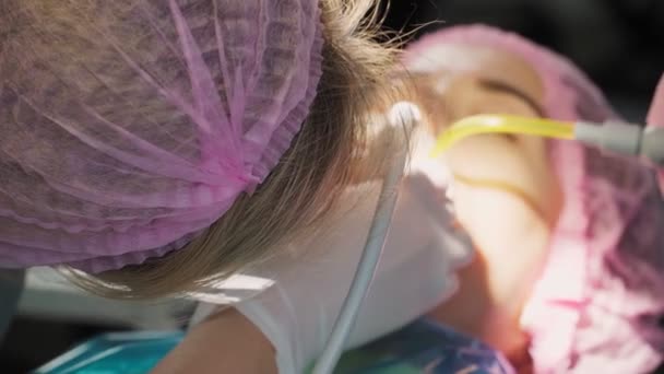Zahnärztin Mit Schutzschild Und Gesichtsmaske Arbeitet Mit Einer Patientin Mit — Stockvideo
